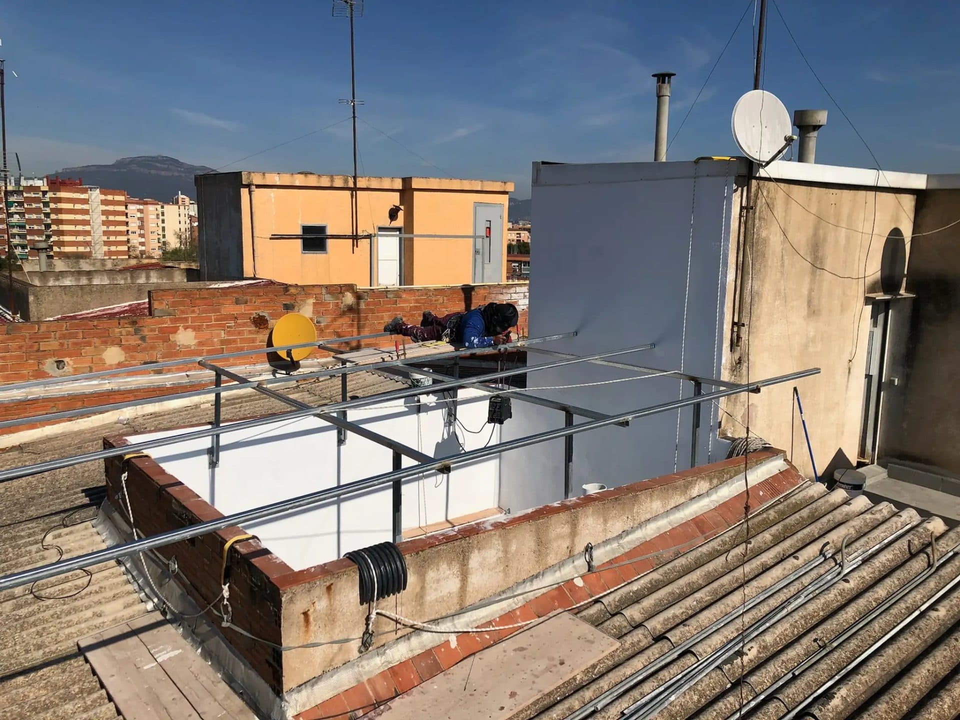 Técnico instalando la estructura metálica de la nueva claraboya en la cubierta