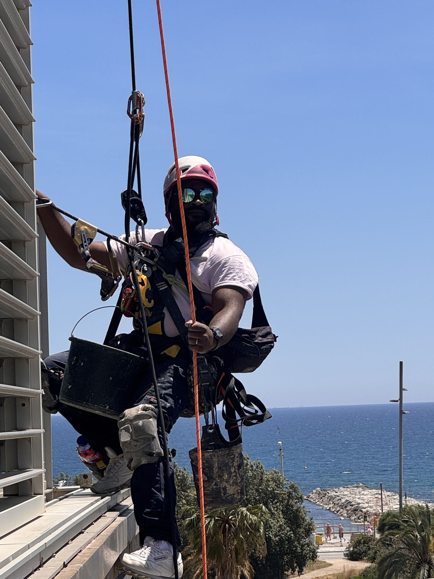 Operario de Invia trabajando por cuerda junto al mar